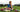 Smiling boy sitting on a grass field with a ball and a pair of Nike Football Shoes with SmellWell inserts in them.