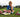 Smiling boy sitting on a grass field with a ball and a pair of Nike Football Shoes with SmellWell inserts in them.