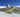 Man on skiis in the middle of a jump doing a spin