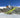 Man on skiis in the middle of a jump doing a spin
