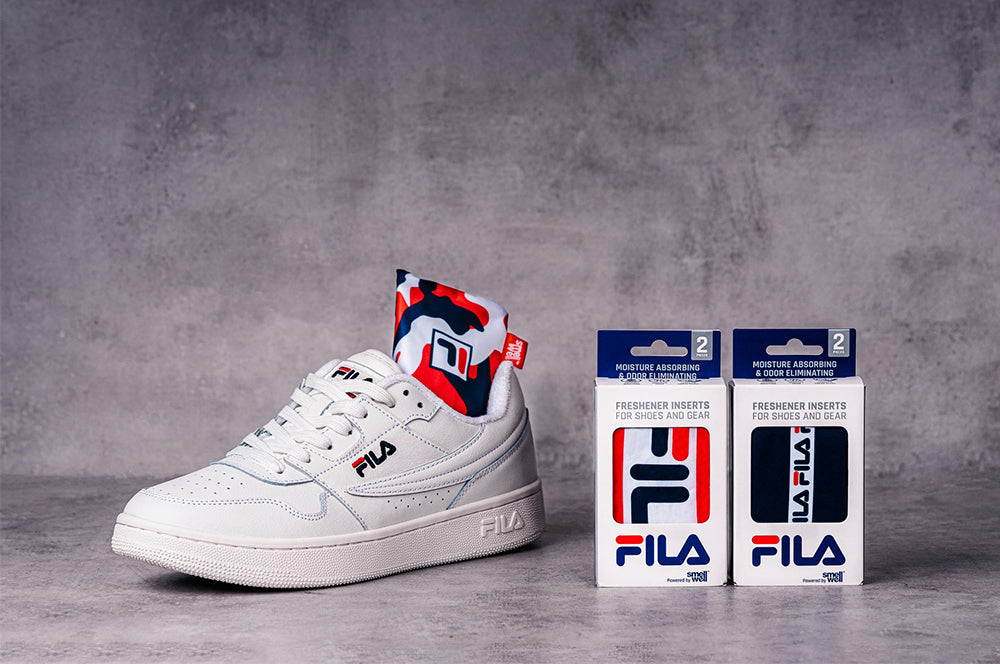 White FILA sneaker with SmellWell Active insert and two packages of SmellWell & FILA Collab Inserts