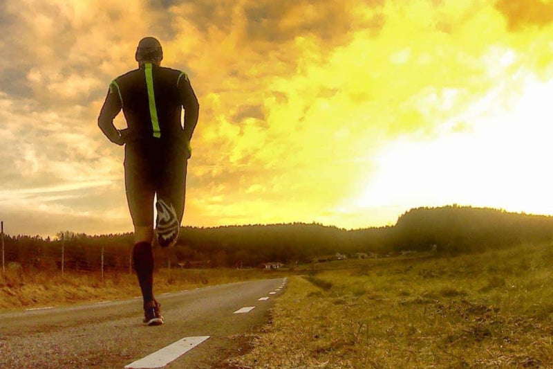 Man running on a road into the sunset