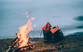 A pair of outdoor shoes with SmellWell Inserts inside them, infront of a fireplace outside