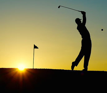 The contours of a person swinging a golf club in the sunset