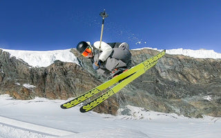 Man on skiis in the middle of a jump doing a spin