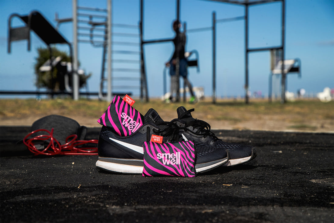 A Pair of SmellWell Active - Pink Zebra in a pair of black runningshoes