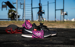 A Pair of SmellWell Active - Pink Zebra in a pair of black runningshoes