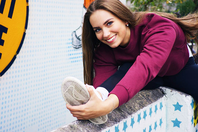 Young woman in pink sweater stretching 