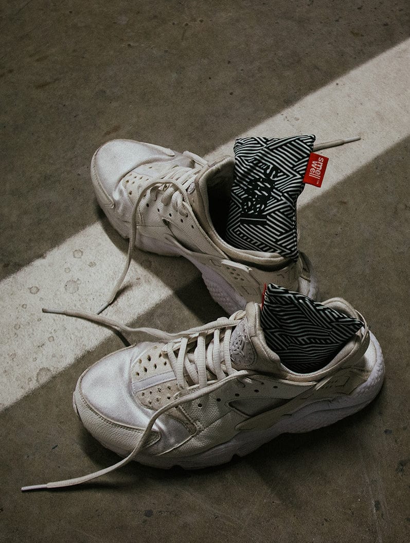 A pair of SmellWell Active - White Stripes put in a pair of used and walked in sneakers